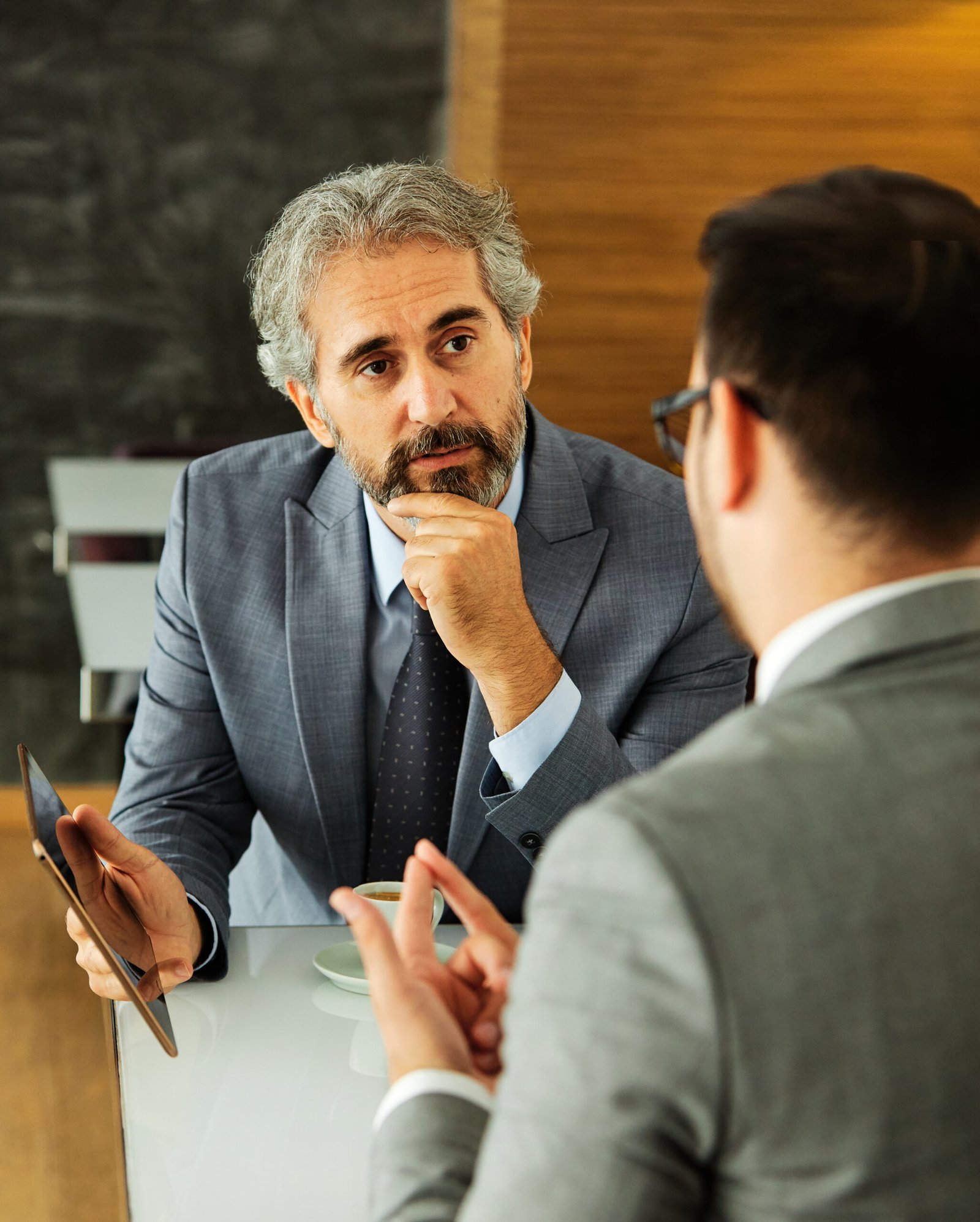 business businessman senior mature office meeting entrepreneur man tablet technology working computer wireless communication discussion executive restaurant coffee shop businessmen businessperson two